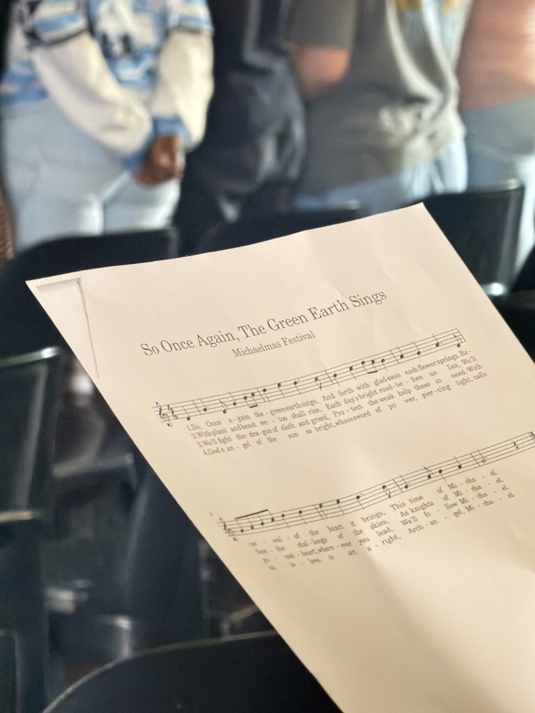 A song sheet held by a student during a school festival assembly