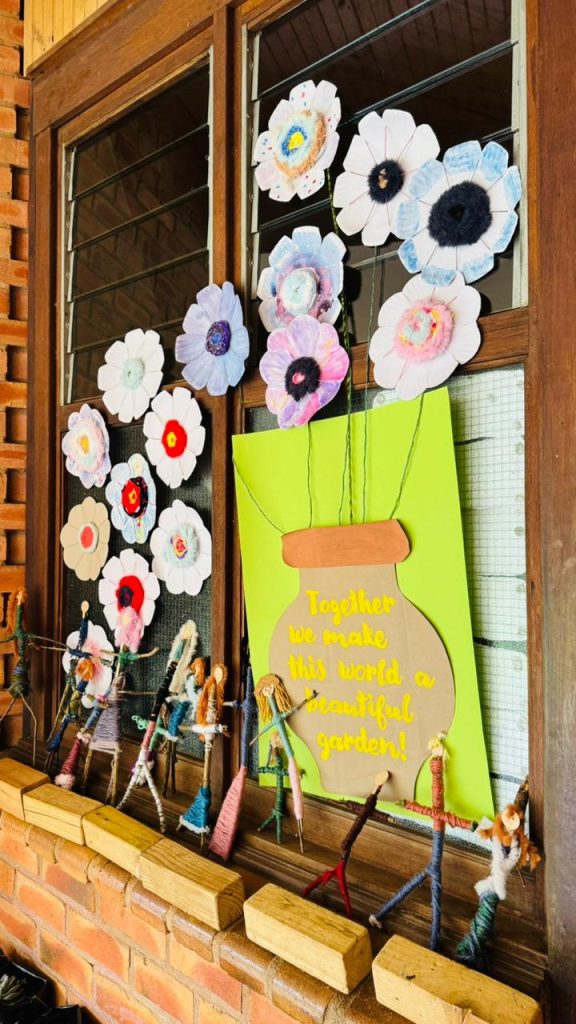 Paper flowers and artwork displayed in a window at the Arts Festival