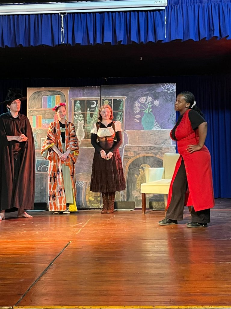 Four actors in costume on stage in the Class 12 play