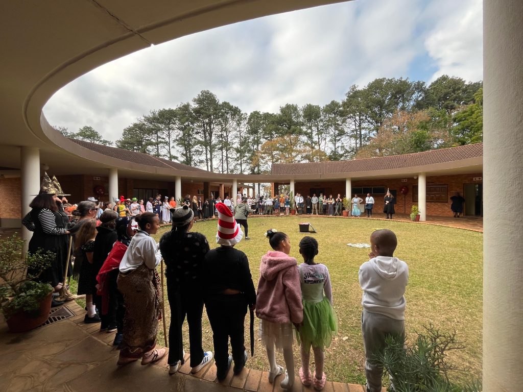 Children in book character costumes gathered around the Circle, seen from behind