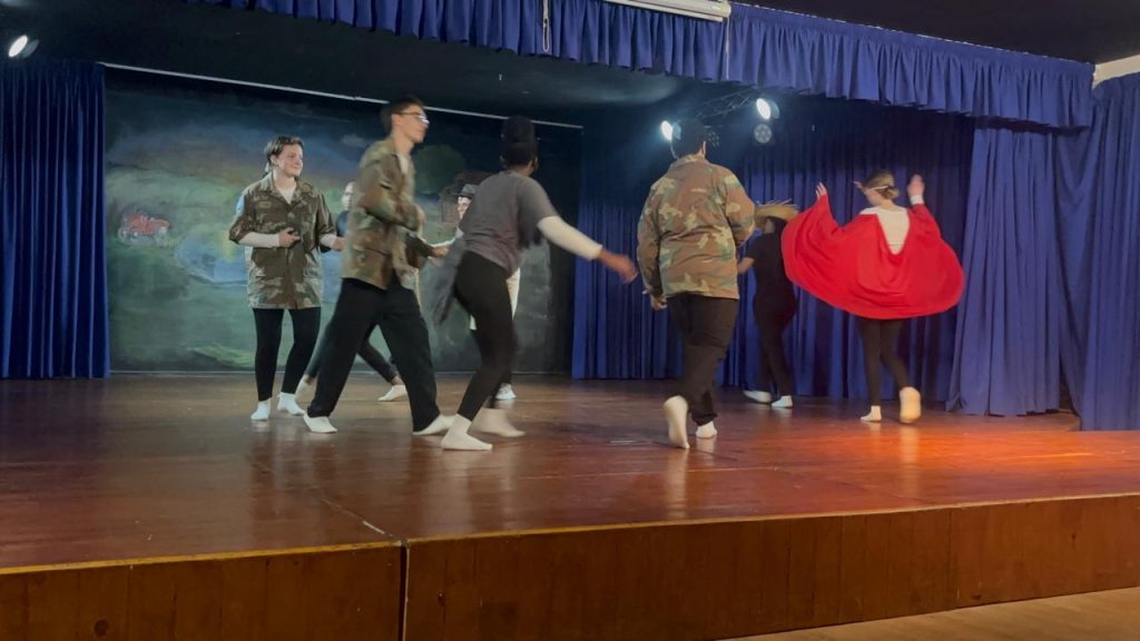 Class 12 students performing a movement piece on the school hall stage